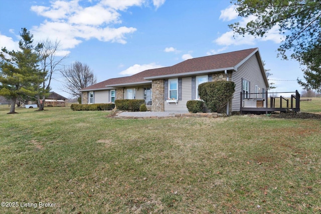 single story home featuring a deck, a front lawn, and stone siding