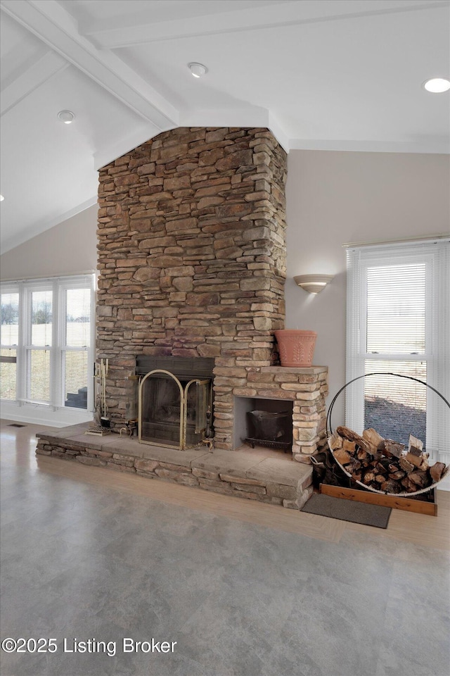 living area with a stone fireplace and lofted ceiling with beams