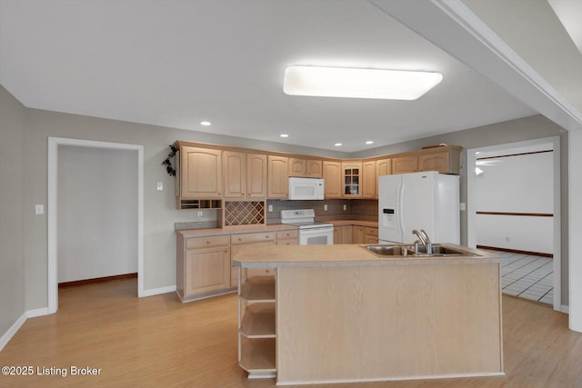 kitchen with white appliances, light wood-style flooring, a sink, light brown cabinetry, and backsplash