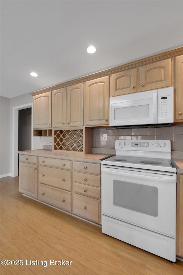 kitchen featuring white appliances and light brown cabinets