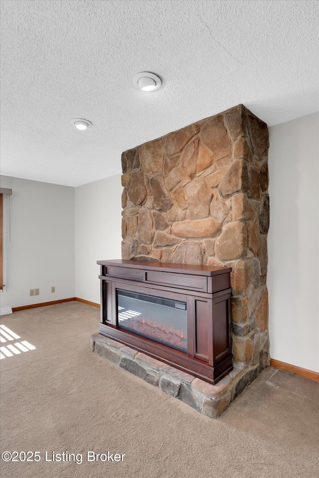 interior details with visible vents, baseboards, carpet floors, a fireplace, and a textured ceiling