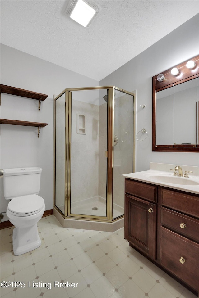 full bath with vanity, a stall shower, a textured ceiling, tile patterned floors, and toilet