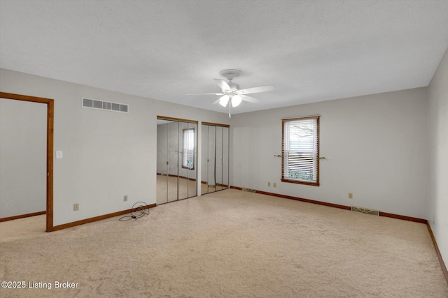 interior space with visible vents, a ceiling fan, and baseboards