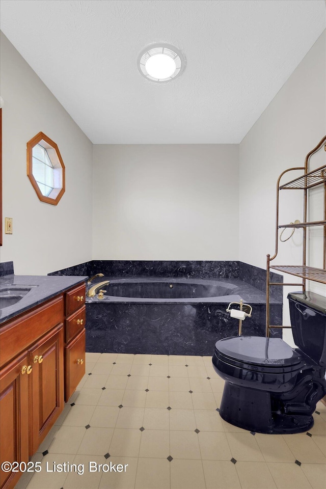 bathroom featuring a washtub, toilet, and vanity