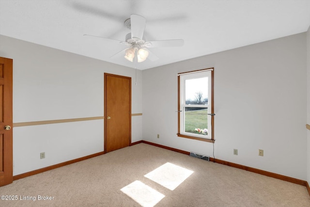 unfurnished room with ceiling fan, carpet, visible vents, and baseboards