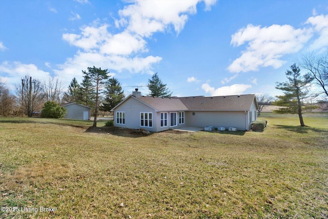 rear view of property featuring a yard and a chimney