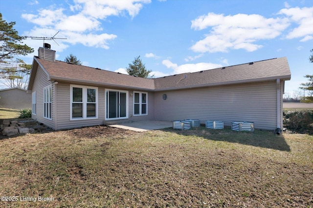 rear view of house featuring a yard, roof with shingles, a chimney, and a patio area