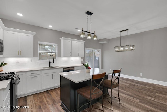 kitchen featuring dark wood-type flooring, black appliances, a sink, tasteful backsplash, and white cabinetry