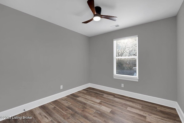 unfurnished room featuring ceiling fan, visible vents, baseboards, and dark wood-style floors