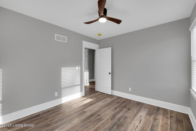 unfurnished bedroom with visible vents, baseboards, wood finished floors, and a ceiling fan