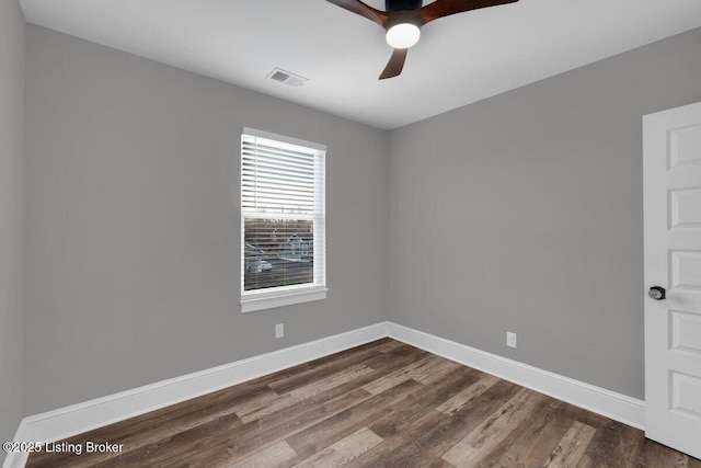 unfurnished room with visible vents, baseboards, a ceiling fan, and dark wood-style flooring