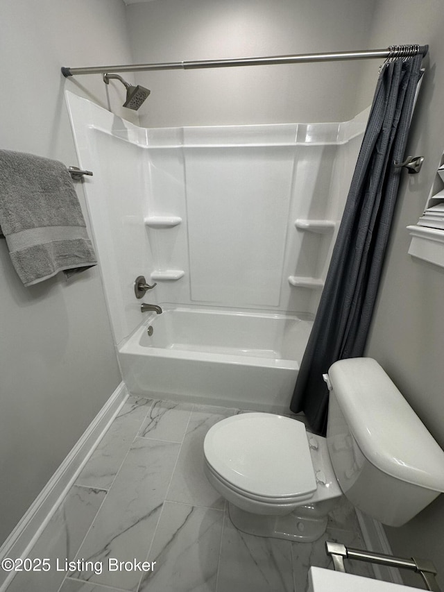 bathroom featuring baseboards, shower / bath combo with shower curtain, toilet, and marble finish floor