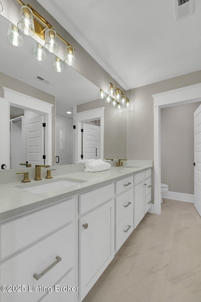 bathroom with double vanity, visible vents, and a sink