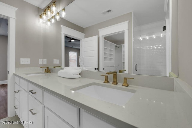 bathroom featuring double vanity, visible vents, a stall shower, and a sink