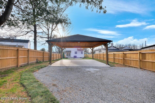 exterior space with a gazebo, a fenced backyard, and driveway