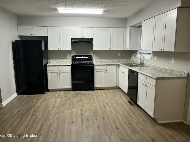 kitchen with light wood-style flooring, a sink, black appliances, extractor fan, and white cabinets