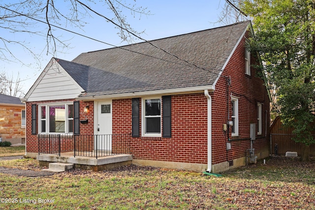 view of front of home with brick siding and a shingled roof