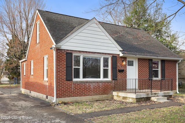 bungalow featuring crawl space, brick siding, and a shingled roof