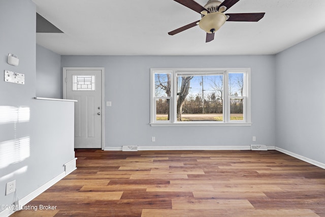 foyer entrance with a ceiling fan, wood finished floors, visible vents, and baseboards