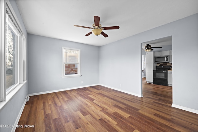 unfurnished room with baseboards, dark wood-type flooring, and a ceiling fan