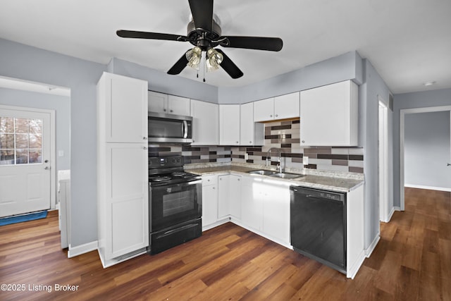 kitchen with a sink, decorative backsplash, black appliances, and white cabinetry