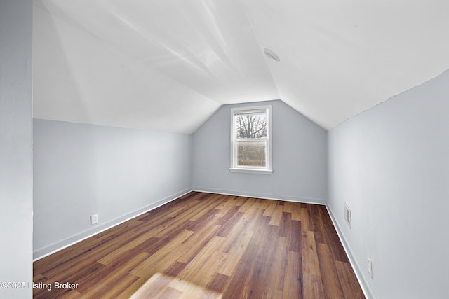 additional living space featuring visible vents, baseboards, wood finished floors, and vaulted ceiling