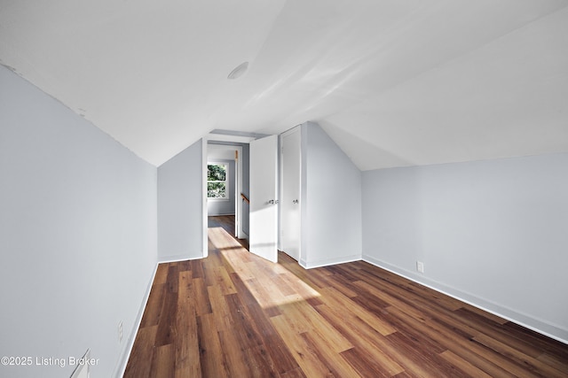 additional living space featuring lofted ceiling, wood finished floors, and baseboards