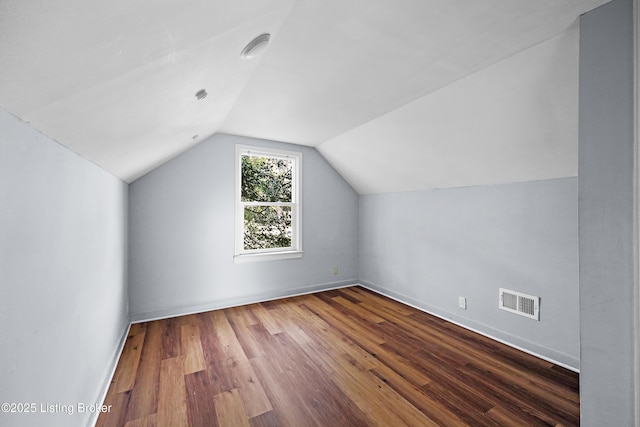 bonus room with lofted ceiling, wood finished floors, visible vents, and baseboards