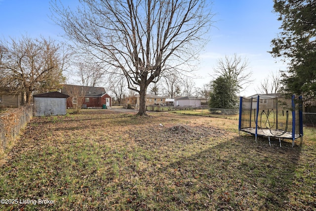 view of yard with a trampoline and fence