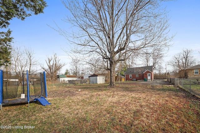 view of yard featuring a storage shed, an outdoor structure, a trampoline, and a fenced backyard