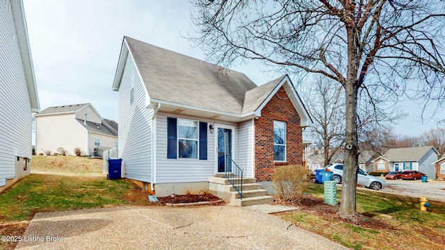 view of front of home featuring brick siding and a shingled roof