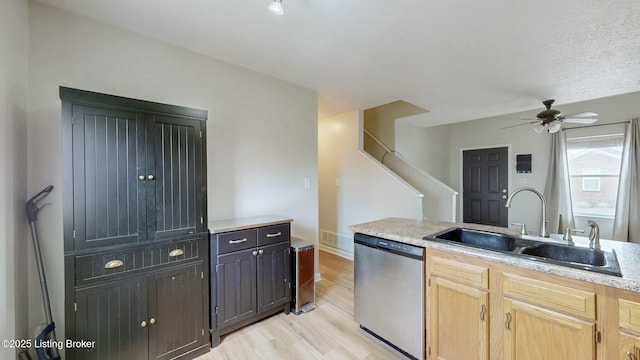 kitchen featuring light wood finished floors, a ceiling fan, a sink, stainless steel dishwasher, and light countertops