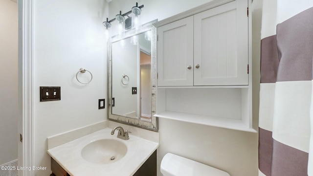 half bathroom featuring visible vents, toilet, and vanity