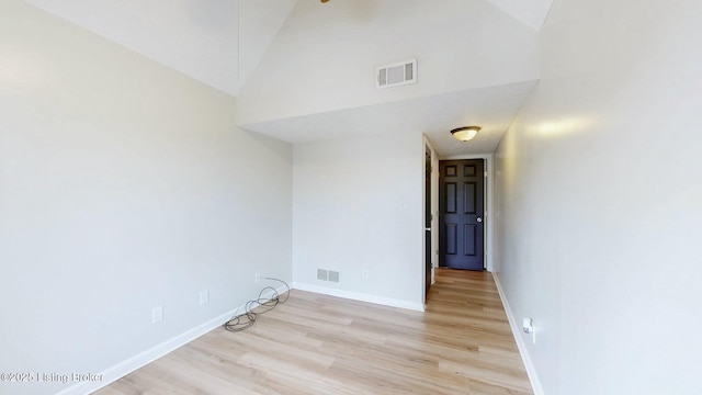 empty room with baseboards, visible vents, and light wood finished floors