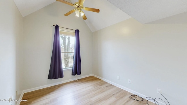 spare room with light wood finished floors, ceiling fan, baseboards, and lofted ceiling