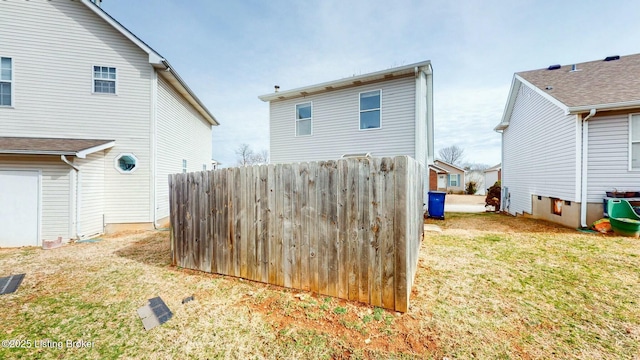 rear view of property with a yard and fence