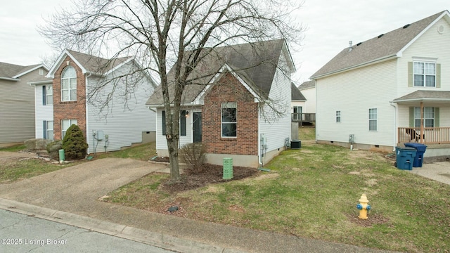 traditional home featuring brick siding, cooling unit, and a front lawn