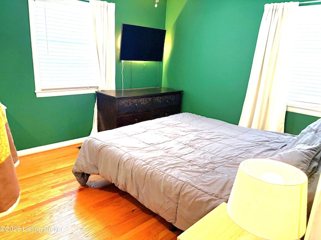 bedroom featuring wood finished floors and baseboards