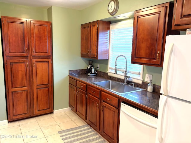 kitchen with white appliances, light tile patterned floors, and a sink