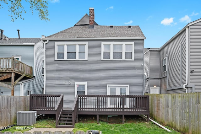 back of property featuring central air condition unit, a chimney, a fenced backyard, and a deck