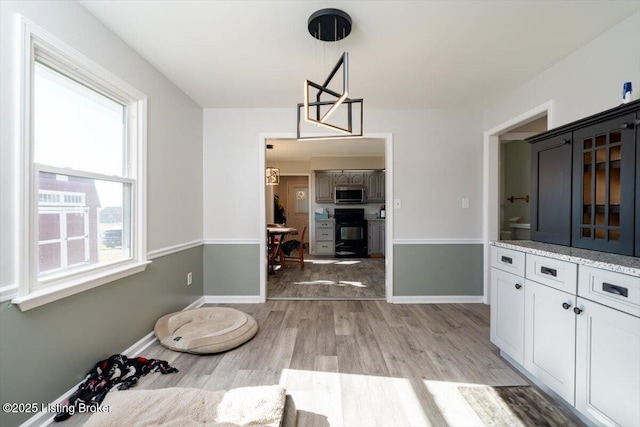 dining space with light wood-style floors and baseboards