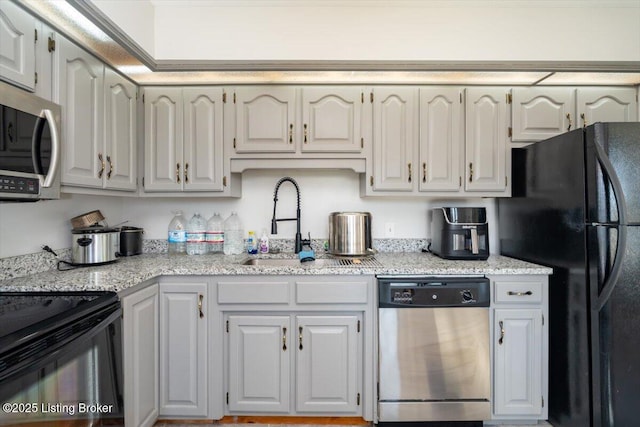 kitchen featuring a sink, light stone countertops, and black appliances