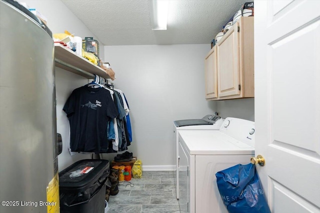 laundry room featuring washer and clothes dryer, cabinet space, a textured ceiling, and baseboards