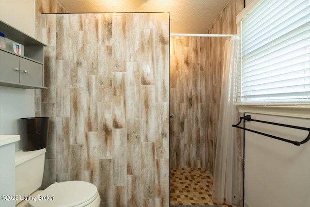 bathroom featuring toilet and tiled shower