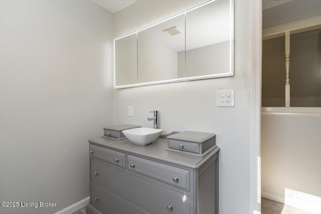 bathroom featuring visible vents, baseboards, and vanity