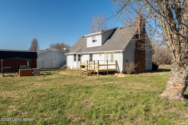 back of property with a wooden deck, a yard, and roof with shingles