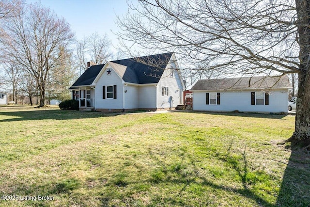 back of property featuring a yard and a chimney