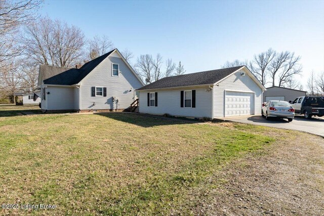 view of front of house with a detached garage and a front yard