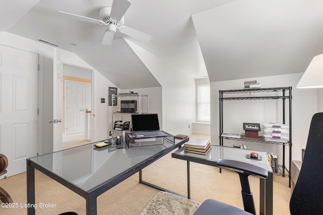 home office featuring lofted ceiling, a ceiling fan, visible vents, and carpet floors