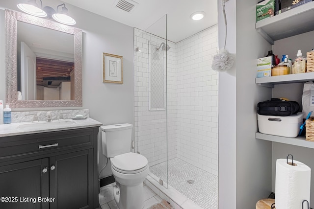 full bathroom featuring vanity, toilet, visible vents, and tiled shower